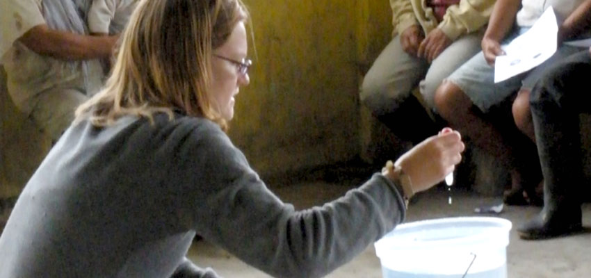 Kendra Johnson demonstrating how to chlorinate water in La Encañada, Ecuador, 2009.