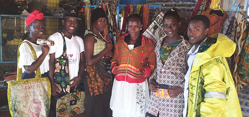 The Kimuli Fashionability team showcases some of its products that it has recently created. The founder, Juliet Namujju (far left), became inspired to blend African fabrics with recyclable materials based on her childhood experience of watching her grandmother practice her trade as a tailor.