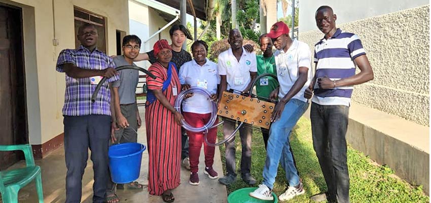 The team poses with the water pump. Left to right: Cosmas (Kulika Uganda), Tarek (D-Lab), Ruta, Alex (D-Lab), Carol (Kulika Uganda), Isaac, Sunday, Amos (Andre Foods International), Philip (Kulika Uganda). Photo: Courtesy Tarek Meah.