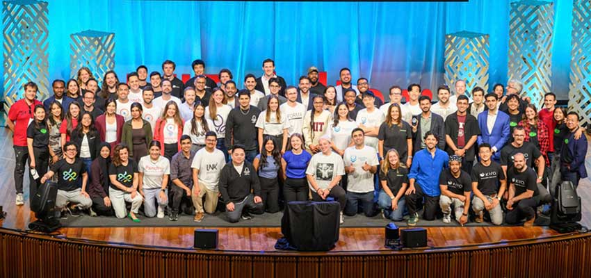 The 2025 delta v accelerator cohort poses on stage for a group photo at the delta v demo day. Credits: Image: Courtesy of the Martin Trust Center 