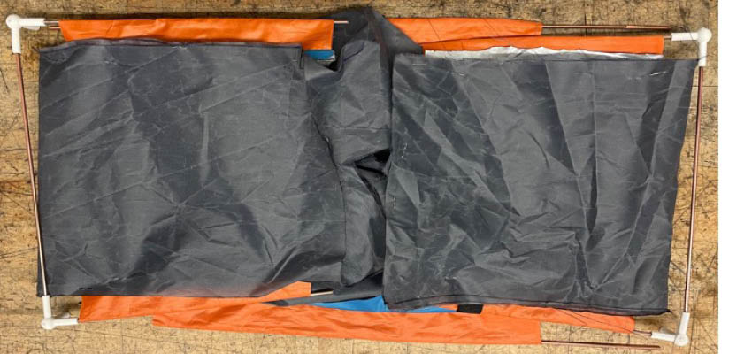 A pvc pipe rectangle framing cloth on table.