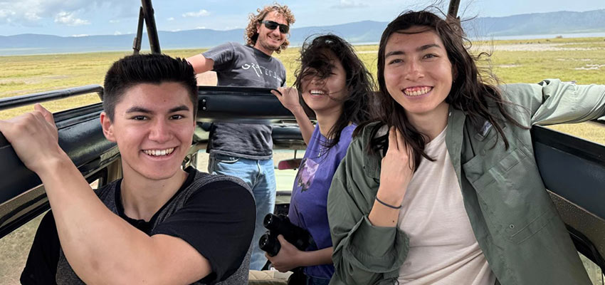 Four people in an open jeep-type vehicle.