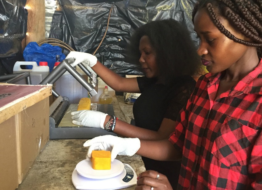 Joan Nalubega (back) and Monica Nantongo are putting the final touches on a batch of their mosquito-repellent soap. Joan’s company, Uganics, has tested their product in Germany. The company sells to individuals as well as businesses, such as hotels.